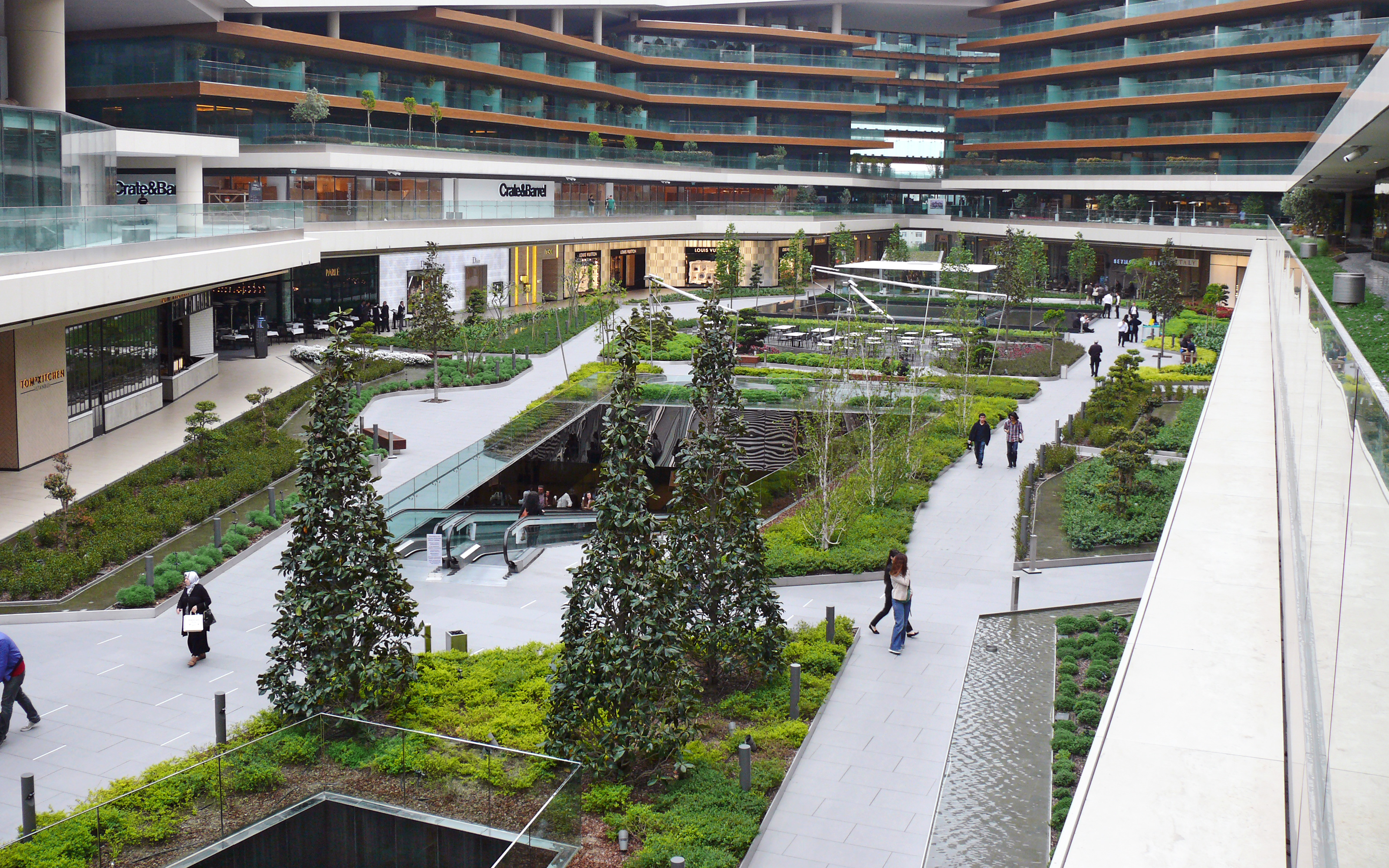 The main square is connected directly to the underground parking decks and the public transport via escalators. Bird's eye view of the vegetated main square with escalators